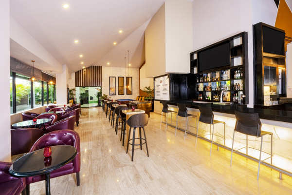 Bar interior y área lounge de estilo moderno con barra de bebidas y café en Hotel Smart Cancun