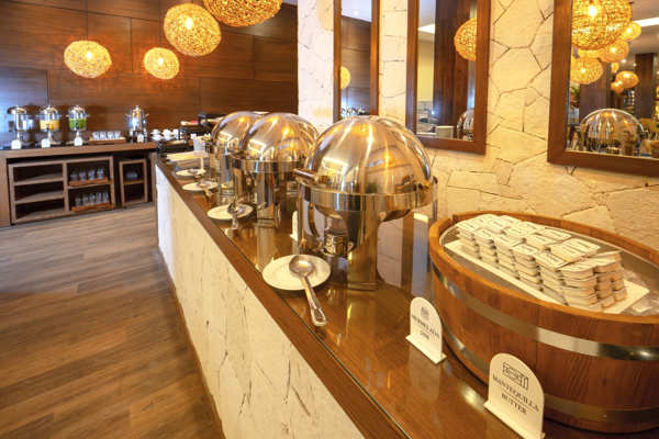 Estación de buffet con variedad de platillos mexicanos e internacionales en el restaurante del hotel