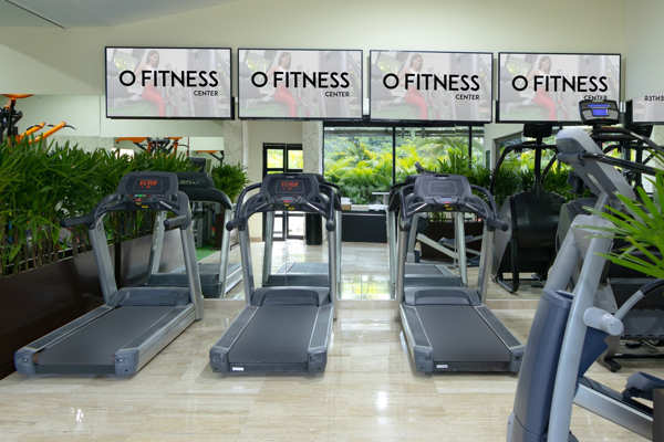 Gimnasio moderno del hotel con máquinas de cardio y pesas para huéspedes