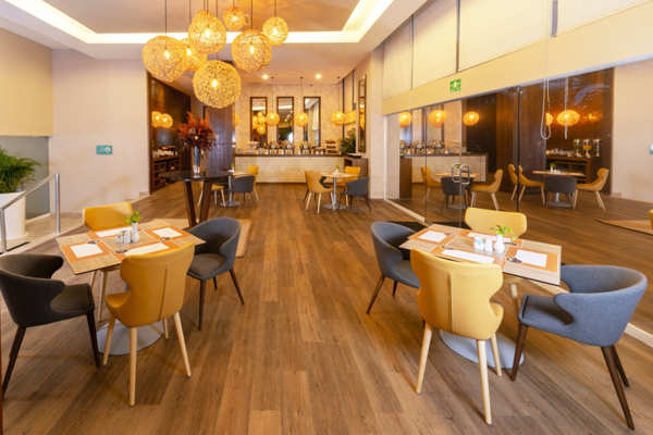 Restaurante iluminado del hotel donde se sirven desayunos buffet y opciones a la carta