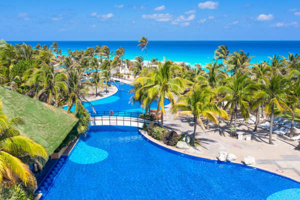 Huéspedes relajándose en la extensa alberca principal de Grand Oasis Cancún