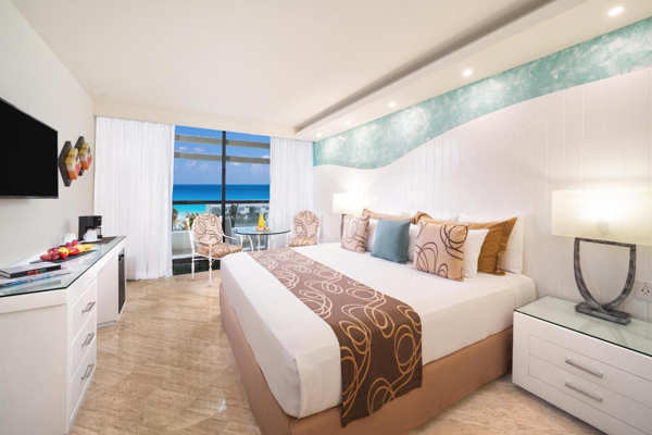 Cama de alta gama y amenidades premium en suite de Grand Oasis Cancún